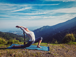 Image showing Sporty fit woman practices yoga Anjaneyasana in mountains