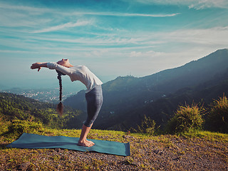 Image showing Woman doing yoga Sun salutation Surya Namaskar outdoors