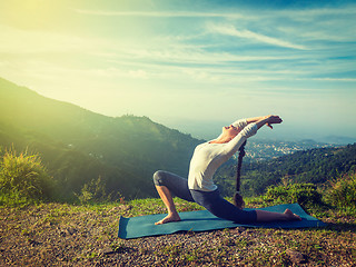 Image showing Sporty fit woman practices yoga Anjaneyasana in mountains