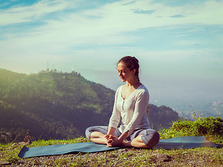 Image showing Sporty fit woman practices yoga asana Baddha Konasana outdoors