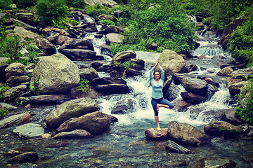 Image showing Woman in  yoga asana Vrikshasana tree pose at waterfall outdoors