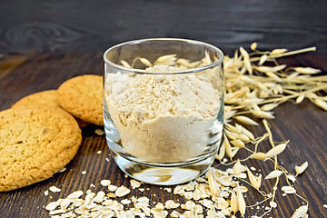 Image showing Flour oat in glass with cookies on board