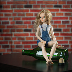 Image showing doll with a bottle. the concept of alcoholism