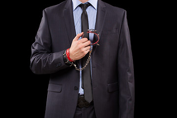 Image showing man in a business suit with leather bound. handcuffs. sex Toys