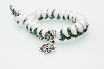 Image showing green braided bracelet on white background. snowflake