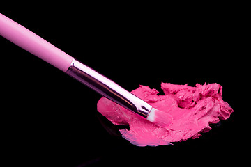 Image showing lipstick with a brush make-up on black 