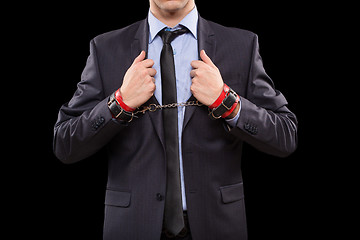 Image showing man in a business suit with leather bound. handcuffs. sex Toys