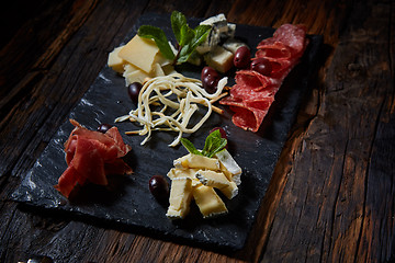 Image showing Salami and cheese platter with herbs