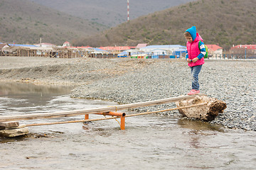 Image showing Five-year girl timidly comes on board thrown across the stream