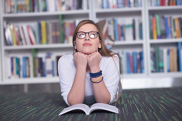 Image showing female student study in library, using tablet and searching for 