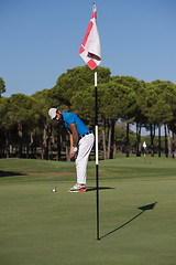 Image showing golf player hitting shot at sunny day