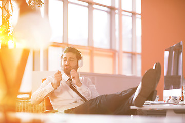 Image showing relaxed young businessman first at workplace at early morning