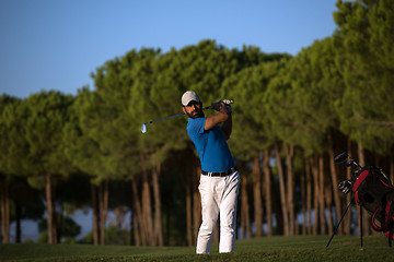 Image showing golfer hitting a sand bunker shot on sunset