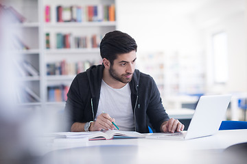 Image showing student in school library using laptop for research