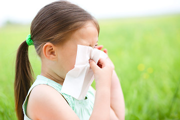 Image showing Little girl is blowing her nose