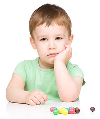 Image showing Portrait of a sad little boy with candies