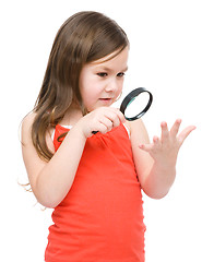 Image showing Little girl is looking at her palm using magnifier