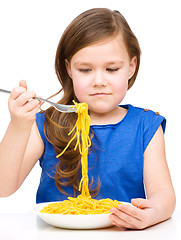 Image showing Little girl is eating spaghetti