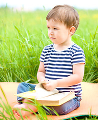 Image showing Little boy is reading book