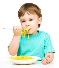 Image showing Little boy is eating spaghetti