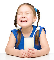 Image showing Sad little girl with a glass of milk