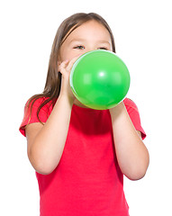 Image showing Little girl is inflating green balloon