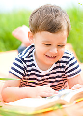 Image showing Little boy is reading book