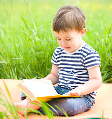 Image showing Little boy is reading book