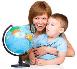 Image showing Mother is looking at globe with her son