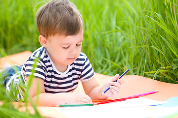 Image showing Little boy is playing with pencils