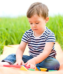 Image showing Little boy is playing with toys