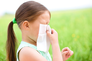 Image showing Little girl is blowing her nose