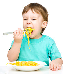 Image showing Little boy is eating spaghetti