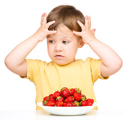 Image showing Little boy refuses to eat strawberries