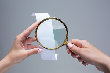 Image showing The female hands with  empty transaction paper or paper check and magnifier