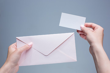 Image showing The female hands with envelope against the gray background