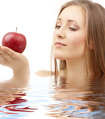 Image showing woman with red apple in water