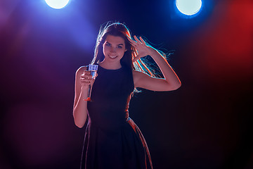 Image showing The beautiful girl dancing at the party drinking champagne