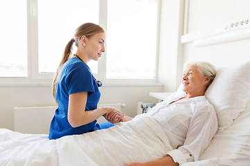 Image showing doctor or nurse visiting senior woman at hospital