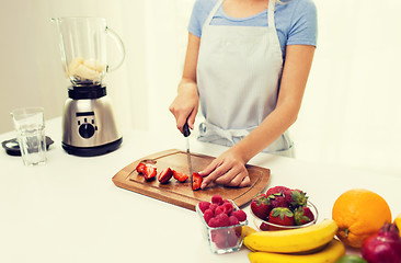 Image showing close up of woman chopping strawberry at home