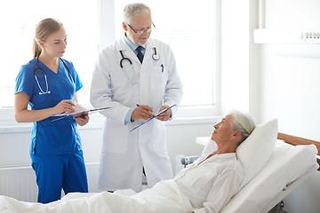 Image showing doctor and nurse visiting senior woman at hospital