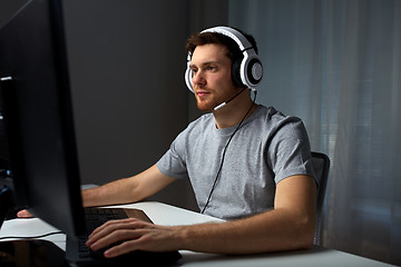 Image showing man in headset playing computer video game at home