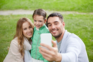Image showing happy family taking selfie by smartphone outdoors