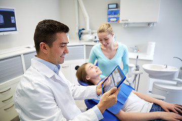 Image showing dentist with x-ray on tablet pc and patient girl