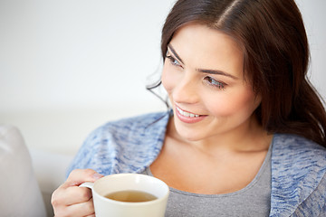 Image showing happy woman with cup of tea at home