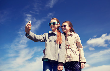 Image showing happy girls with smartphone taking selfie outdoors