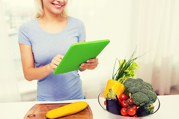 Image showing close up of woman with tablet pc cooking at home