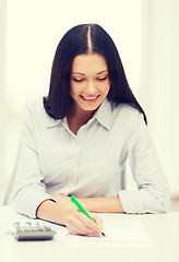 Image showing businesswoman or student working with calculator