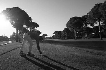 Image showing golf player placing ball on tee