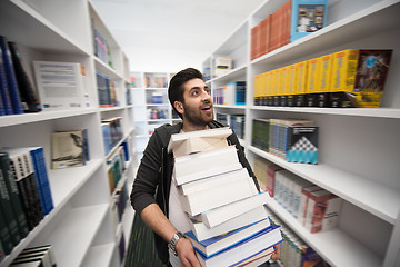 Image showing Student holding lot of books in school library